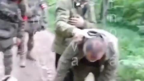 Russian soldiers hit, kick and fire next to the head of Ukrainian POW