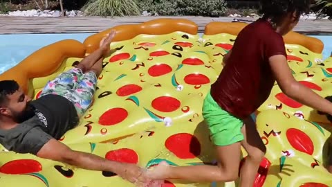 children play with a giant inflatable pizza in Swimming Pool