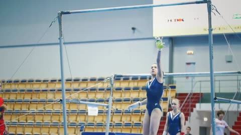 Athletic woman gymnasts performing on bar at the championship