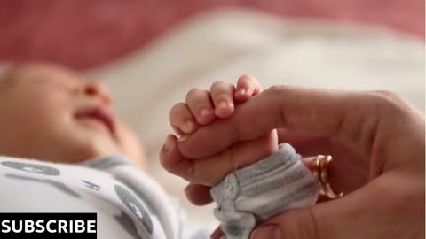 Mother and her newborn baby, parent holding newborns hand