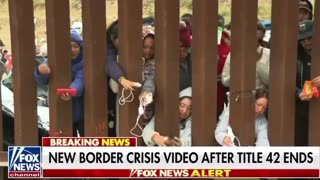 Migrants try to charge phones through border wall