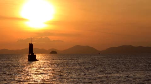 Asian Sailboat Floating On The Sunset Water