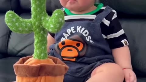 Cute babies playing with dancing cactus