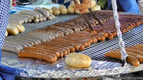 Germany Street Food. Huge Grill of Bratwurst Sausages and Long Skewers