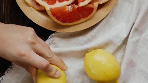 A Person Cutting Lemon into Slices Using a Knife