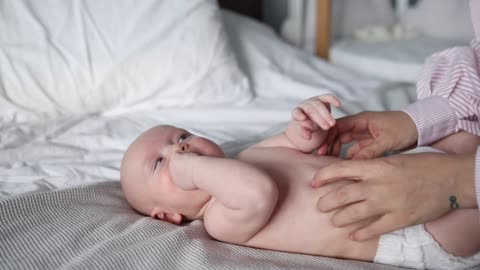 Baby Lying On Bed Wearing Diaper