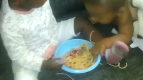 El bebé agarrando la comida de su prima