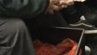 Man eats a cooked pig off the bone on subway train