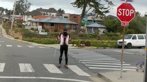Guy skiing on streets with rollerblades red white black jacket