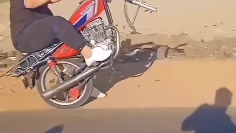 Riding a motorcycle without a front wheel on the rack and falling
