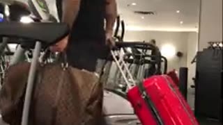 Man Prepares For A Trip By Running On A Treadmill With Luggage