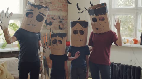 A Family Wearing Handmade Halloween Masks At Home