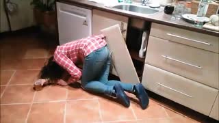 Red plaid shirt women gets shirt stuck in cabinet door breaks door and falls to ground