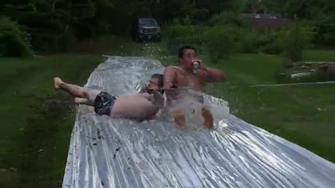 Two guys dragged on slip and slide crash into group bowling