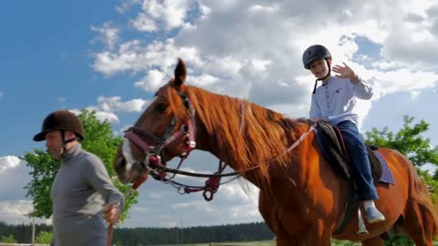 Happy little boy riding on the horse