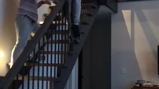 Slow sliding down black stair case fail hits floor