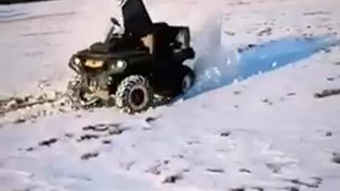 White helmet rides four wheeler on snow turns it over