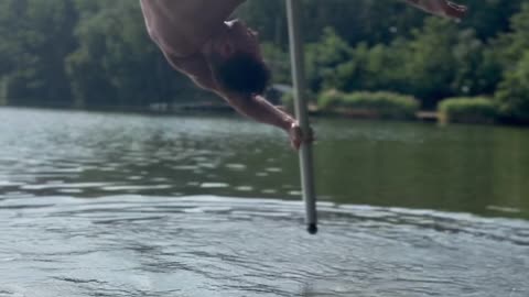 Man Dances On Flying Pole Over Peaceful Lake