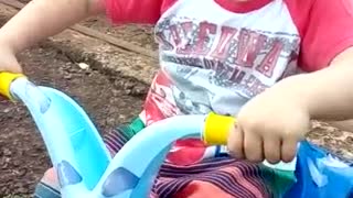 Little boy in a blue toy motorcycle falls over