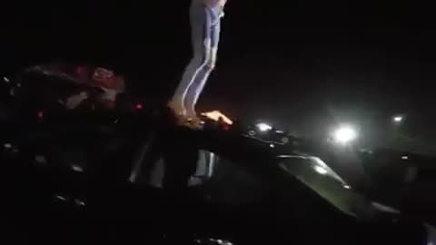 Shirtless ripped jeans guy dancing on top of black car slips face plant