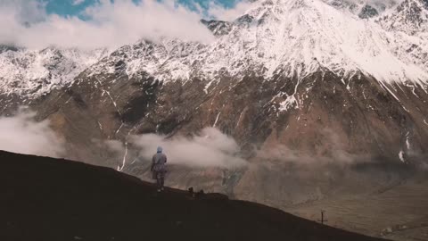 Person Standing in Front of Majestic Mountains