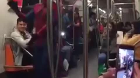 Chubby spiderman on subway train dances spanish music