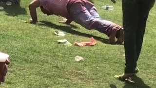 Man at holi festival does push ups in field