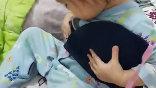 Baby attempts to drink milk from mom's bra
