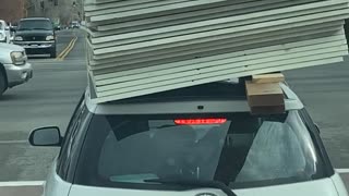 Building Supplies Barely Balanced on Car Roof