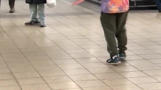 Tie dye shirt beard man spins to music in subway terminal