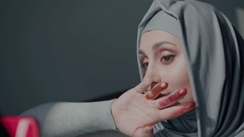 A Muslim girl playing makeup, is amusing