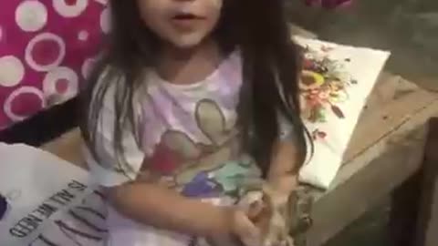 niña de 5 años juega con un gran zapo