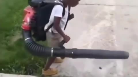 Child tries to blow the grass