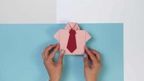 Woman Placing Origami Shirts One over Other