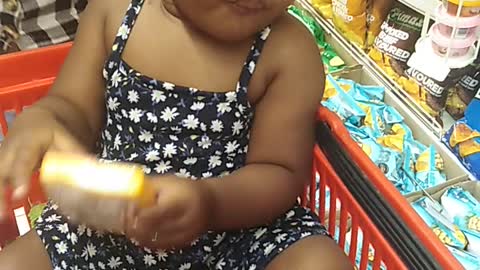 Baby enjoying cheese while her mom does shopping