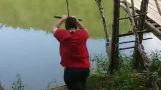 Red shirt rope swing guy falls into water