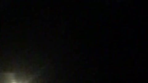 Slowly hovering purple UFO at night