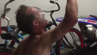 Shirtless guy getting beer blown into face