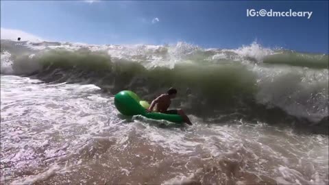 Slowmo green float guy gets destroyed by ocean wave
