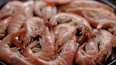 Boiled big sea prawns or shrimps placed on black ceramic plate