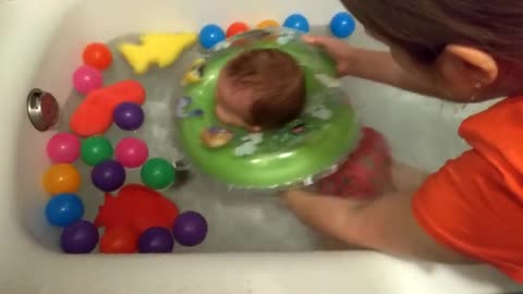 Cute_baby_has_fun_in_the_water_with_colorful_balls