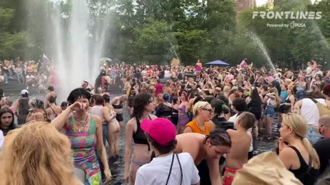 Children and adults are playing together at a clothing-optional Pride water party in Washington Park