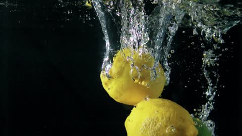 Slow motion - Lemons falling into water