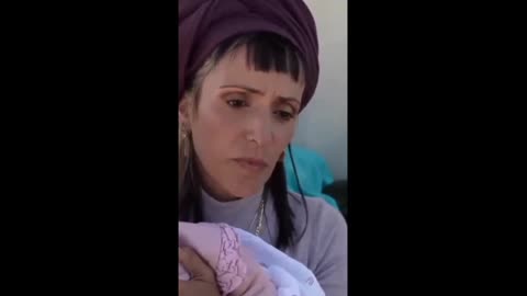Israeli Women Blocks aid while holding her baby