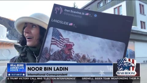 Noor Bin Ladin holds up a blow up of a Dan Scavino tweet in the middle of Davos