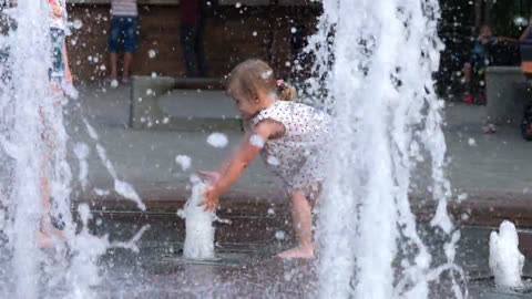Nice Little Girl playing with water fountain