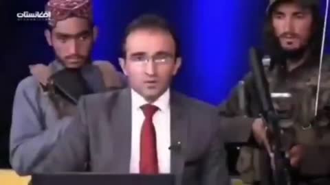 Afghan anchorman read news surrounded by Taliban