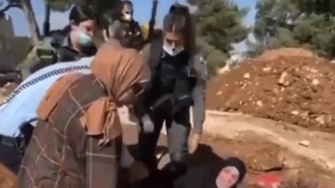 Palestinian mother clings tightly to son's grave as ZIONISTs want to destroy it