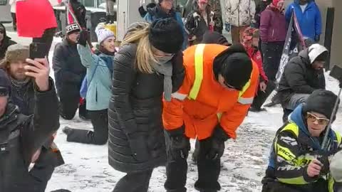 "Ottawa Protesters Kneel in Prayer" as lines of riot units face off with them