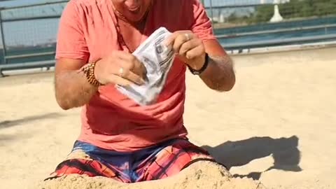 Man searching for money under the sand